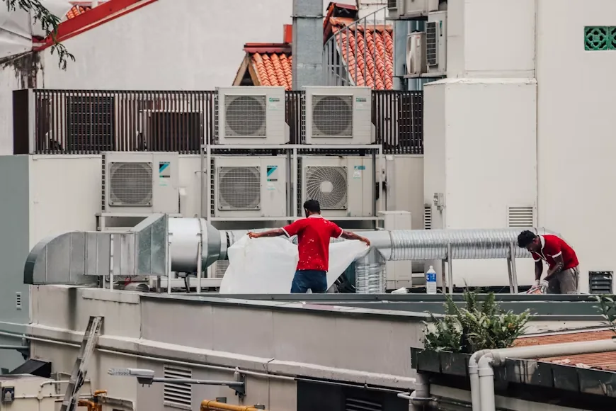 HVAC technicians assessing an air conditioning system before a repair or replace decision